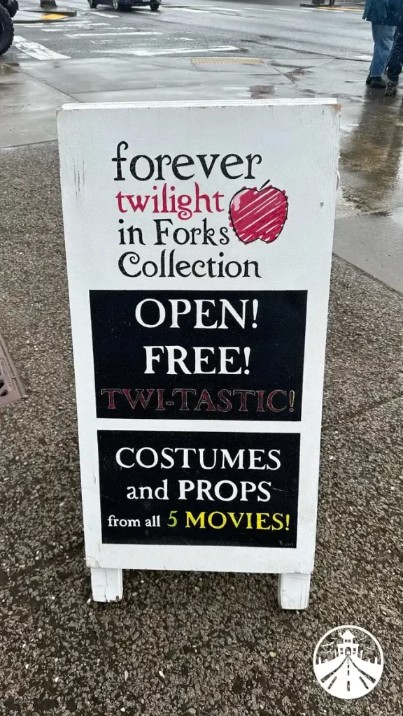 A-frame sign outside the Forks Twilight museum, welcoming visitors with a list of attractions.