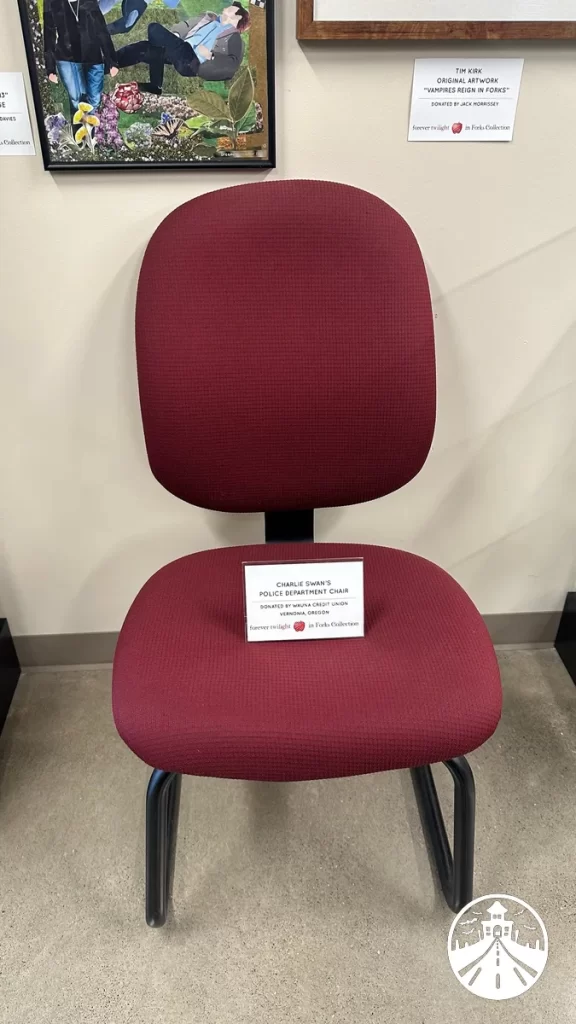 Charlie Swan’s desk chair from Twilight on display at the Forks museum, with a sheriff’s badge and accessories nearby.